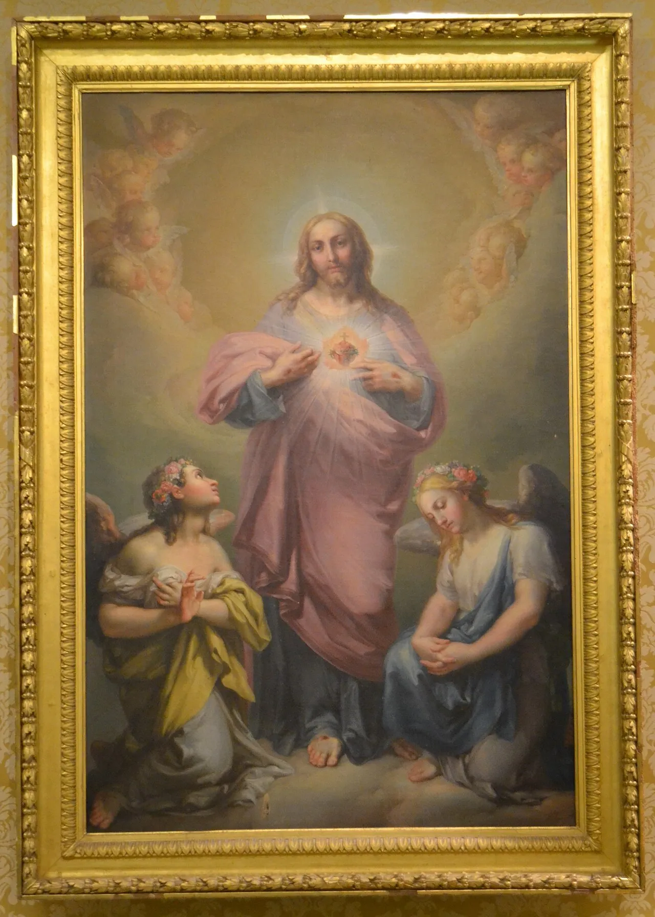 Christus zeigt das heilige Herz, umgeben von einem Kranz aus Cherubim, zu seinen Füßen zwei kniende Engel